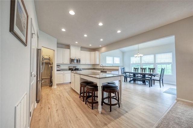 605 Saddle Ct, Moon/Crescent Twp, PA 15108 - kitchen featuring recessed lighting, appliances with stainless steel finishes, white cabinets, light wood-type flooring, and visible vents