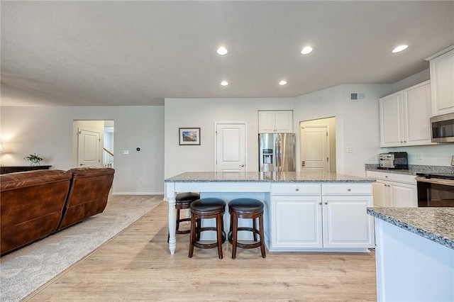 605 Saddle Ct, Moon/Crescent Twp, PA 15108 - kitchen with appliances with stainless steel finishes, white cabinetry, a kitchen island, and light wood-style flooring