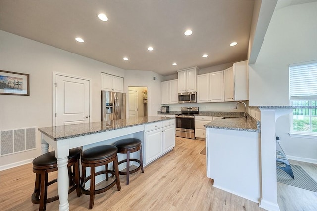 605 Saddle Ct, Moon/Crescent Twp, PA 15108 - kitchen featuring a sink, a kitchen bar, visible vents, a kitchen island, and appliances with stainless steel finishes