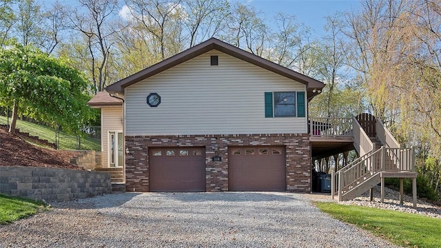 114 Silent Meadow Dr, Washington Twp Wml, PA 15632 - view of property exterior featuring brick siding, stairway, an attached garage, and gravel driveway