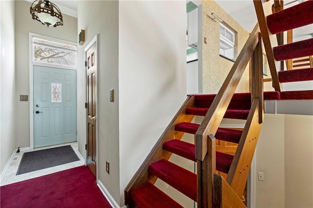 stairs featuring baseboards and ornamental molding