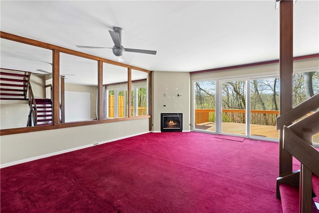 unfurnished living room featuring baseboards, a ceiling fan, a healthy amount of sunlight, and carpet flooring