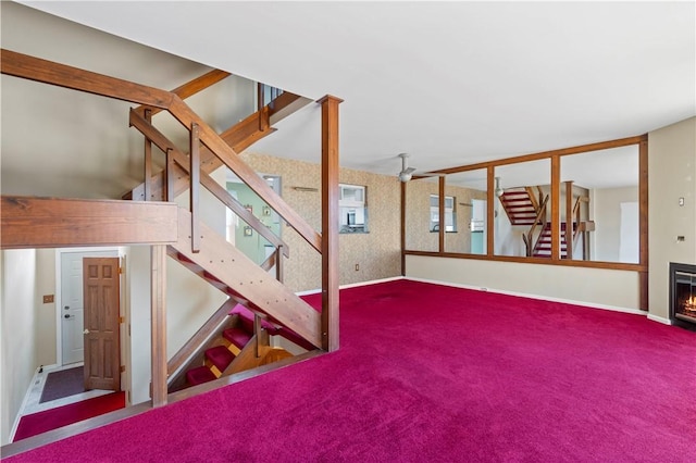 unfurnished living room featuring stairs, carpet, and baseboards