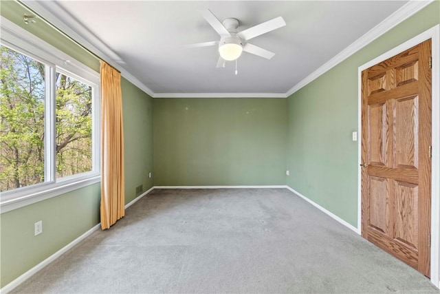 spare room with baseboards, ornamental molding, a ceiling fan, and carpet flooring