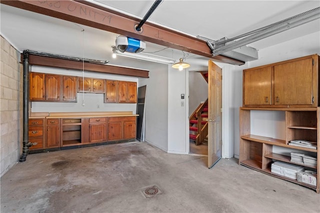 garage with a garage door opener and concrete block wall