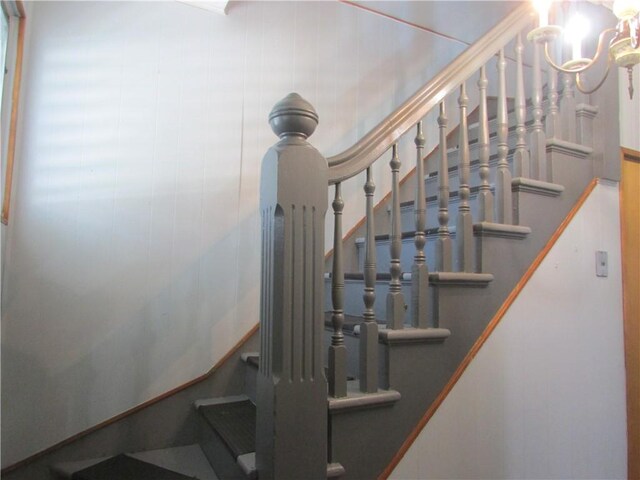 stairs featuring a chandelier