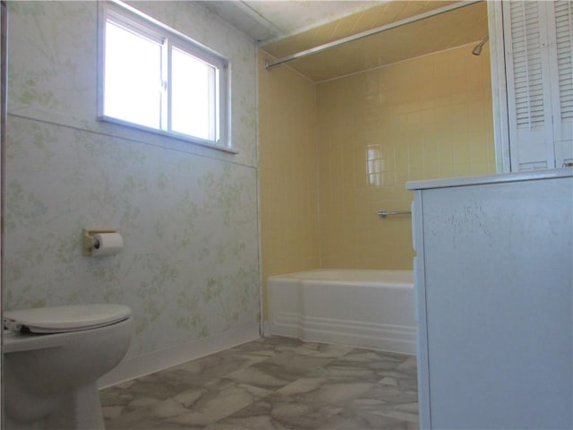 full bath with toilet, shower / tub combination, and baseboards