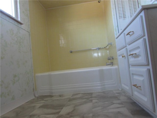 full bath with baseboards and washtub / shower combination