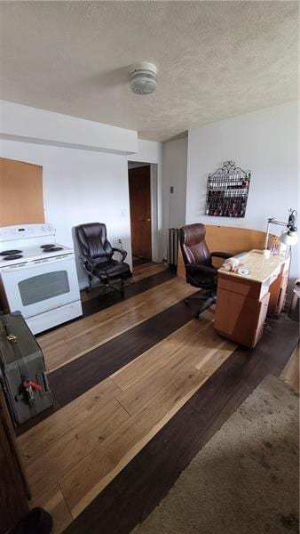 living area with hardwood / wood-style flooring and a textured ceiling
