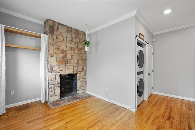 2113 Wharton St, South Side, PA 15203 - clothes washing area featuring hardwood / wood-style floors, stacked washer / dryer, ornamental molding, and baseboards