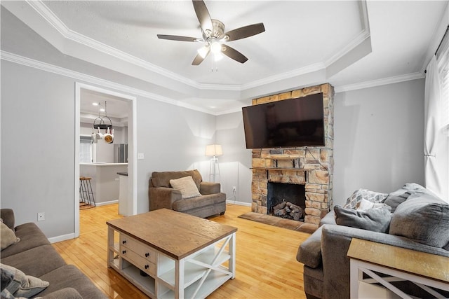 2113 Wharton St, South Side, PA 15203 - living area featuring wood finished floors, ceiling fan, a fireplace, a raised ceiling, and crown molding