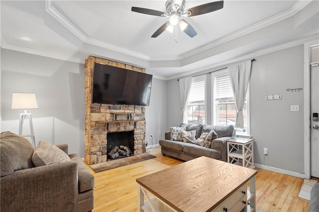 2113 Wharton St, South Side, PA 15203 - living area featuring a fireplace, a raised ceiling, light wood-type flooring, a ceiling fan, and ornamental molding