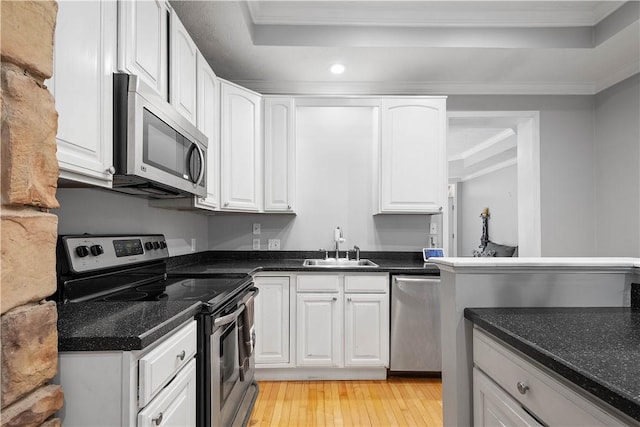 2113 Wharton St, South Side, PA 15203 - kitchen featuring a sink, a raised ceiling, crown molding, white cabinets, and appliances with stainless steel finishes