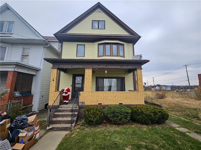 view of front of house featuring brick siding and a porch