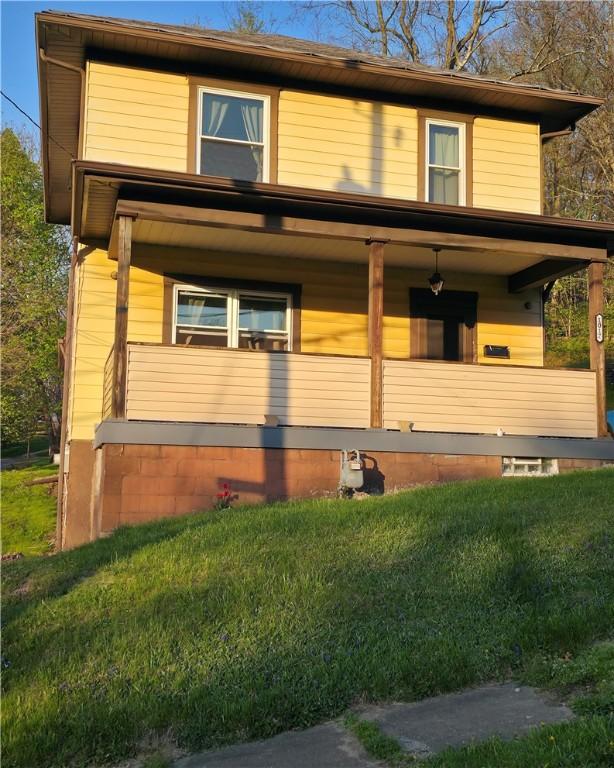 view of front of home with a porch and a front yard