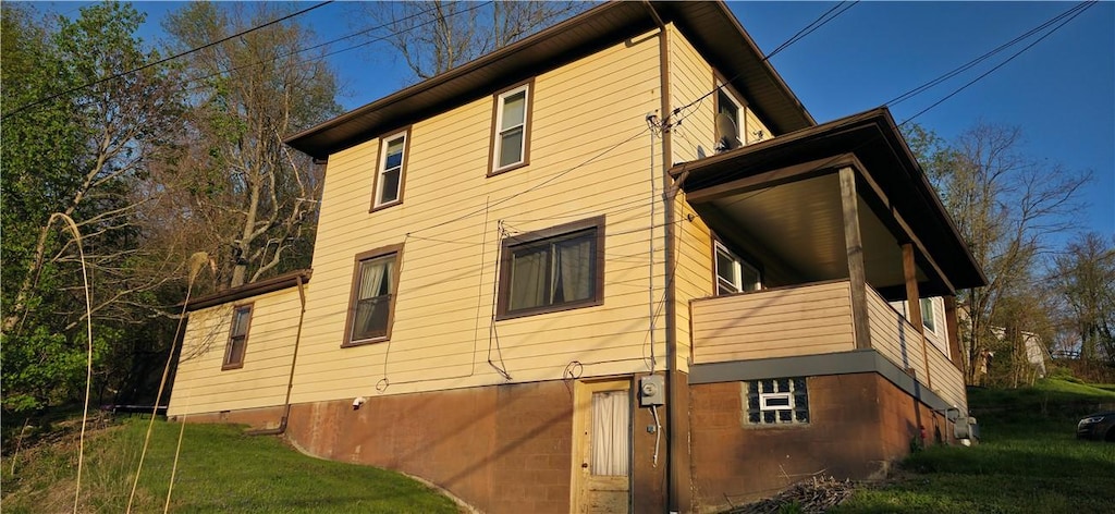 view of side of home with a balcony, a yard, and an attached garage