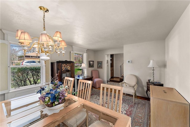227 Gass Rd, Ross Twp, PA 15229 - dining area with a wealth of natural light, baseboards, wood finished floors, and an inviting chandelier