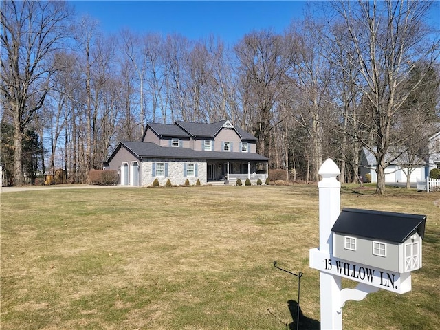 view of front of property with a porch, a front lawn, and stone siding