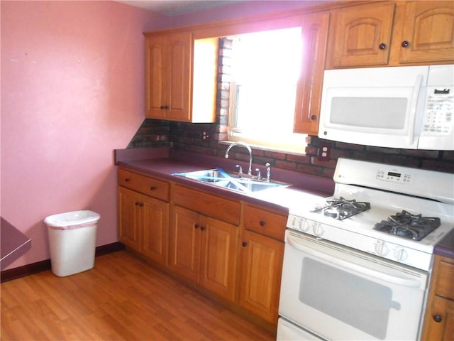 552 Crestline Dr, Baldwin Twp, PA 15234 - kitchen featuring brown cabinets, a sink, white appliances, light wood-type flooring, and backsplash