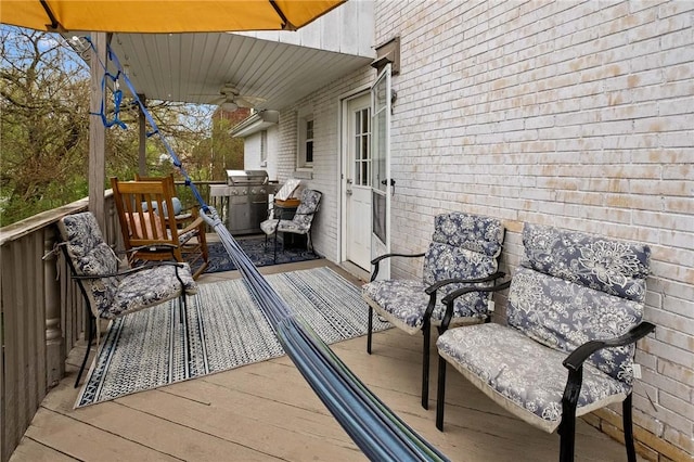 wooden terrace featuring ceiling fan and grilling area