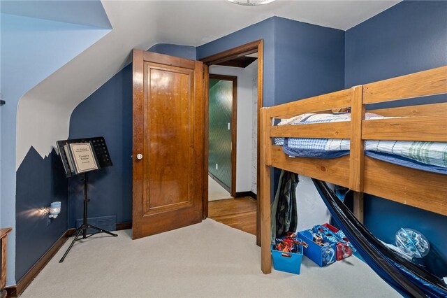 bedroom with carpet flooring and vaulted ceiling
