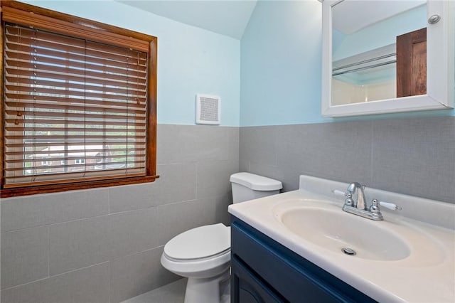 bathroom featuring toilet, tile walls, visible vents, and vanity