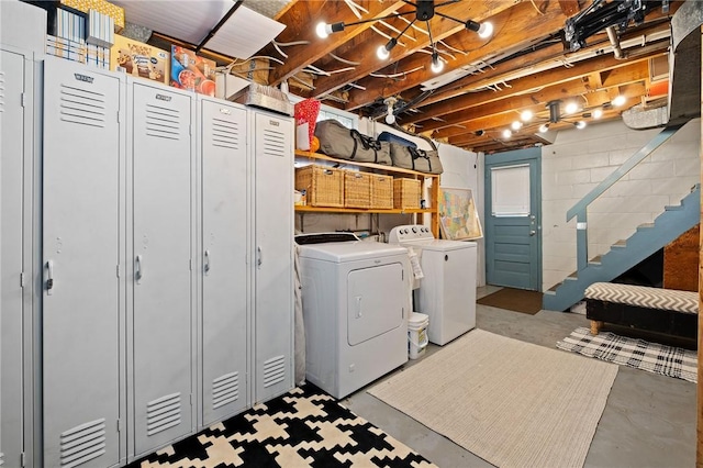 washroom with independent washer and dryer, concrete block wall, and laundry area