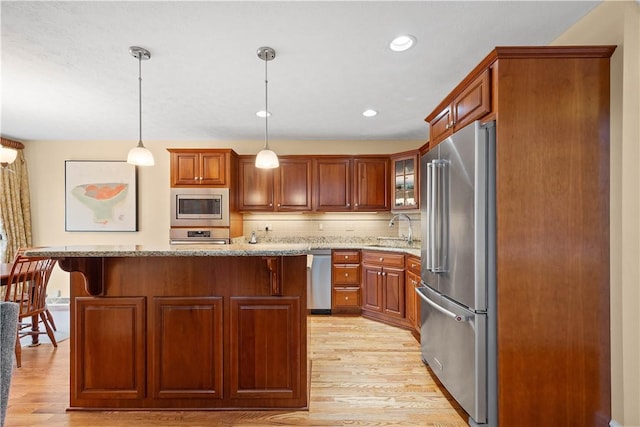 205 Prestonwood Ln, Peters Twp, PA 15317 - kitchen featuring light stone countertops, appliances with stainless steel finishes, a sink, light wood-style floors, and backsplash