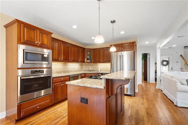 205 Prestonwood Ln, Peters Twp, PA 15317 - kitchen with decorative backsplash, a kitchen island, light wood-type flooring, light stone counters, and appliances with stainless steel finishes