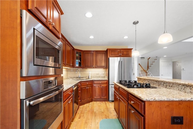205 Prestonwood Ln, Peters Twp, PA 15317 - kitchen with decorative light fixtures, appliances with stainless steel finishes, light stone counters, light wood finished floors, and glass insert cabinets