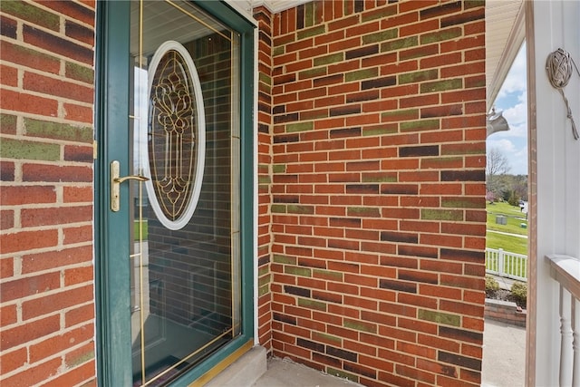 entrance to property featuring brick siding