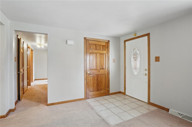entryway with light colored carpet, baseboards, and visible vents