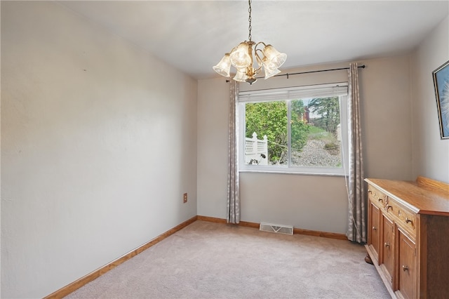 unfurnished dining area with visible vents, baseboards, a chandelier, and light carpet