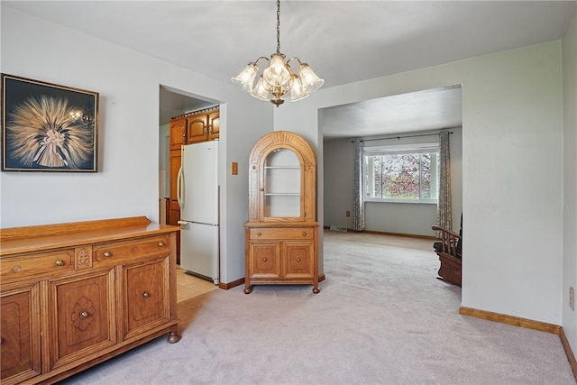 interior space with baseboards, light carpet, and a chandelier