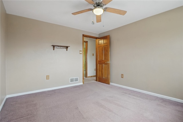unfurnished room with baseboards, ceiling fan, light carpet, and visible vents