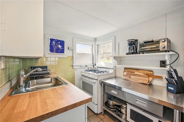 875 Hillside Rd, Jamestown Cra, PA 16134 - kitchen featuring a sink, butcher block countertops, decorative backsplash, light tile patterned floors, and white range with gas stovetop