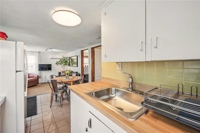 875 Hillside Rd, Jamestown Cra, PA 16134 - kitchen featuring freestanding refrigerator, a wall mounted AC, tasteful backsplash, a sink, and light tile patterned floors