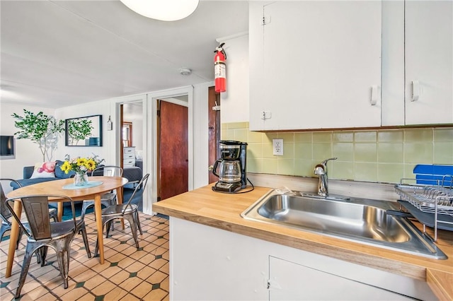 875 Hillside Rd, Jamestown Cra, PA 16134 - kitchen with white cabinetry, decorative backsplash, a sink, and wooden counters