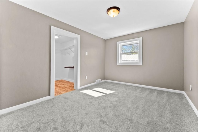 unfurnished room with carpet floors, baseboards, and visible vents