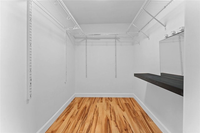 walk in closet with light wood-style flooring