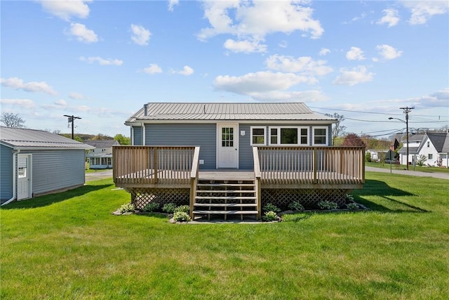 back of house featuring a yard, a deck, and metal roof