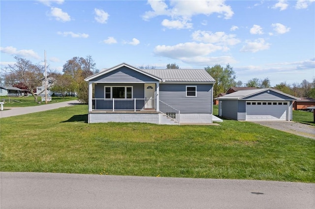view of front of home featuring covered porch, a front yard, metal roof, an outbuilding, and a detached garage