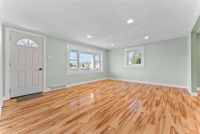 foyer entrance featuring recessed lighting, baseboards, light wood-type flooring, visible vents, and ornamental molding