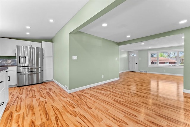 unfurnished living room featuring visible vents, recessed lighting, baseboards, and light wood-type flooring