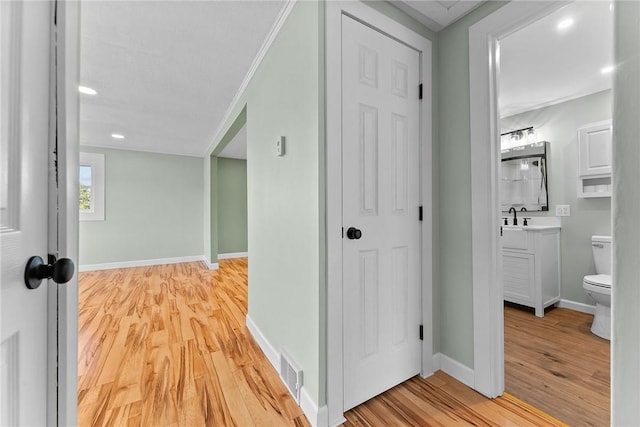 corridor featuring light wood-style floors, baseboards, recessed lighting, and visible vents