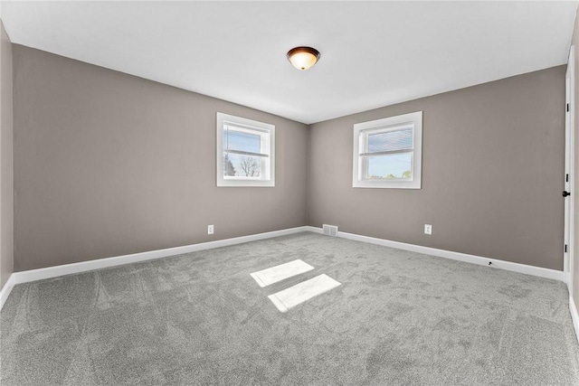 carpeted spare room with baseboards and visible vents