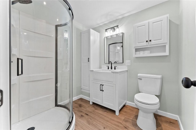 full bathroom with baseboards, a stall shower, toilet, and wood finished floors