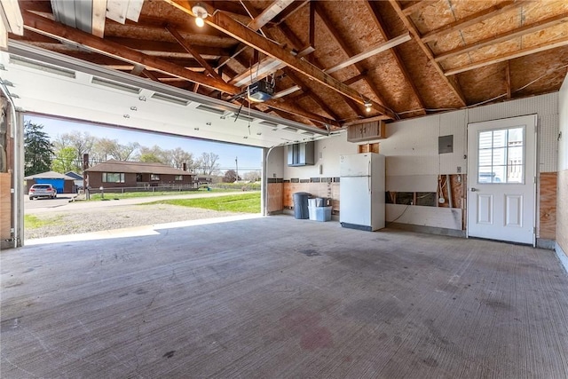 garage with freestanding refrigerator and a garage door opener