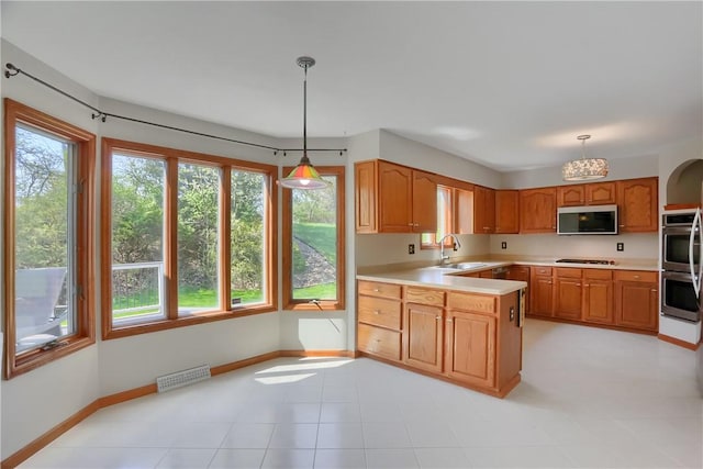kitchen featuring light countertops, a sink, plenty of natural light, and stainless steel appliances