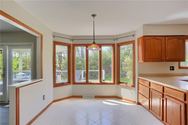 unfurnished dining area with light tile patterned flooring, baseboards, and visible vents